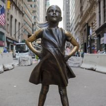 Estatua de una niña frente al toro de Wall Street