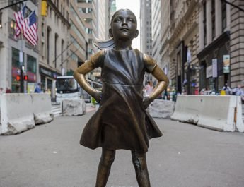 Estatua de una niña frente al toro de Wall Street