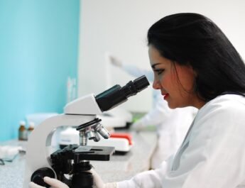 Mujer científica observando por un microscopio