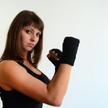 Mujer con guantes de lucha mirando desafiante a la cámara