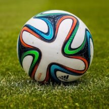 En la imagen aparece un balon de futbol en un campo de futbol. En el sueño hay cesped verde