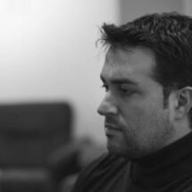 Edu Bayón sentado en un sofá mirando de lado, en una fotografía en blanco y negro