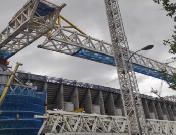 Exterior del estadio Santiago Bernabéu en el que se ven las obras: grúas, lonas para evitar desprendimientos y estructuras metálicas.