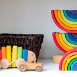 Varios juguetes infantiles, arcoíris y cochecitos de madera.