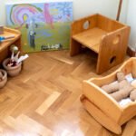 Utensilios de cocina de juguete, cuna de madera de juguete y lienzo pintado por niños.