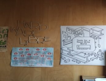 En la imagen aparecen varios posteres en una pared del Medialab. Se puede leer: "Hardware libre" y "herramientas para un mundo legible y editable.