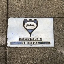 Baldosas frente a la entrada principal del CSA La Tabacalera en la que se muestra un símbolo de ubicación y la siguiente descripción: centro social