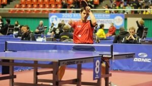 Jugador de mesa adaptado con camiseta roja jde España jugando en una mesa azul