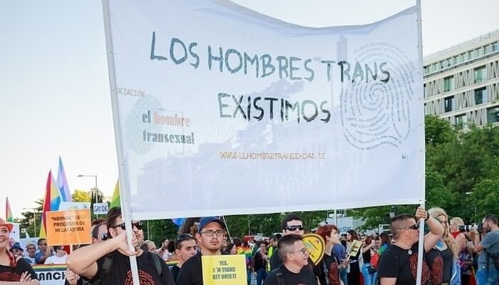 Imagen de una ancarta en una manifestación en la que se puede leer: "Los hombres trans también existen". Varios hombres sujetan la pancarta.