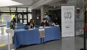Plano general del control de acceso al salón de actos donde se realizan las jornadas donde se puede apreciar dos miembros de staff