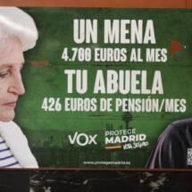 Cartel de Vox donde sale una señora mayor, de blanco y un joven de piel oscura encapuchado y con un pañuelo tapándole la cara.