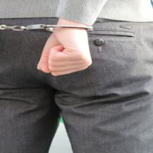 Hombre detenido con las manos esposadas tras la espalda