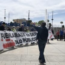 Pensionistas de Fuenlabrada, vistiendo chalecos amarillos, sujetan una pancarta en la que se lee: "Fuenlabrada en defensa de lo público". Un hombre con un megáfono corea cánticos delante de ellos.