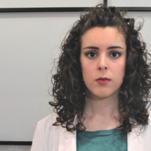 Primer plano, busto parlante de una mujer con el rostro serio.