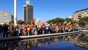 Manifestación de Vox en la Plaza de Colón. Se ven a los manifestantes con banderas de España al filo de la fuente en medio de la Plaza.