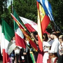 Grupo de personas con banderas en un festival de folclore
