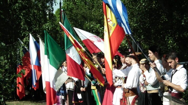 Grupo de personas con banderas en un festival de folclore