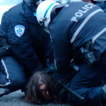 Policías deteniendo a persona en el suelo