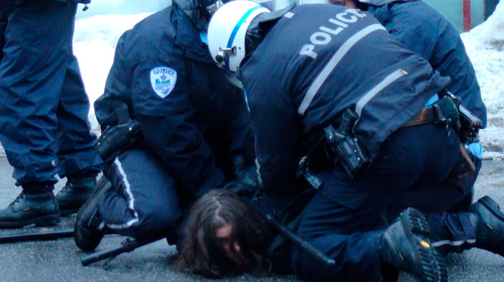 Policías deteniendo a persona en el suelo