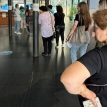 En la foto propuesta se aprecia una fila de personas para ser atendidas en un Hospital con ademanes de desesperación.