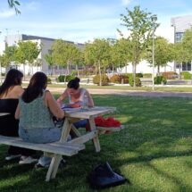 Grupo de chicas conversando en una mesa exterior de la Universidad Rey Juan Carlos, en el campus de Fuenlabrada.
