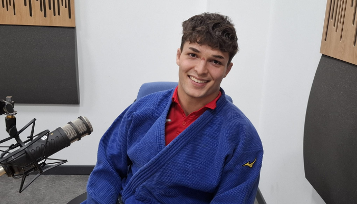 Aharón Santamaría sonriente, vistiendo un judogi azul en un estudio de grabación