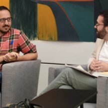Escudero Paniagua y Silvestre Llamas están charlando, sentados en dos sillones grises, en la presentación del libro