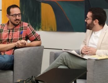 Escudero Paniagua y Silvestre Llamas están charlando, sentados en dos sillones grises, en la presentación del libro