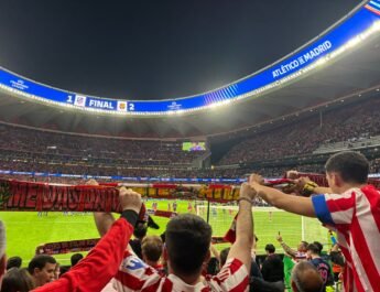 La hinchada atlética alza sus banderas y bufandas. Al fondo, se ve el resultado en el videomarcador.