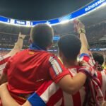 Dos aficionados del Atlético de Madrid se abrazan durante el partido