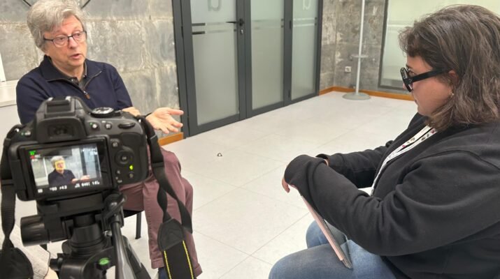 Javier de la Cueva sentado siendo entrevistado por Karen Cano en una habitación cerrada. El entrevistado está de frente y el entrevistador de perfil